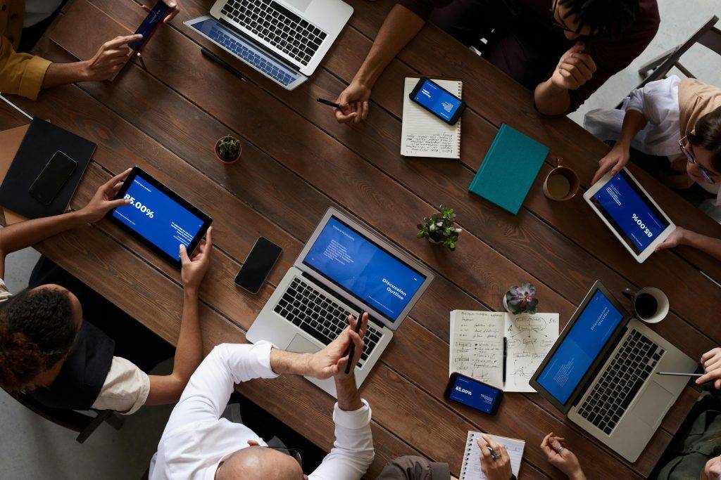 group of business people around a table with laptops and phones. Attribution Photo by fauxels: https://www.pexels.com/photo/people-having-business-meeting-together-3183183/