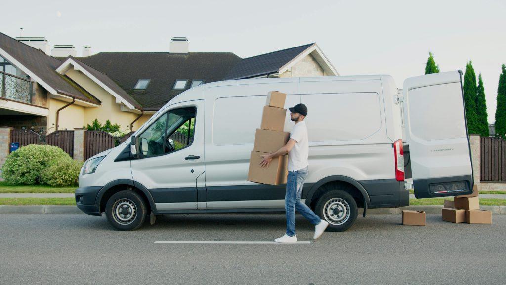 White van with person carrying pachages to be delivered