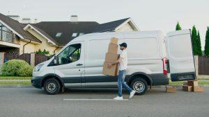 White van with person carrying pachages to be delivered