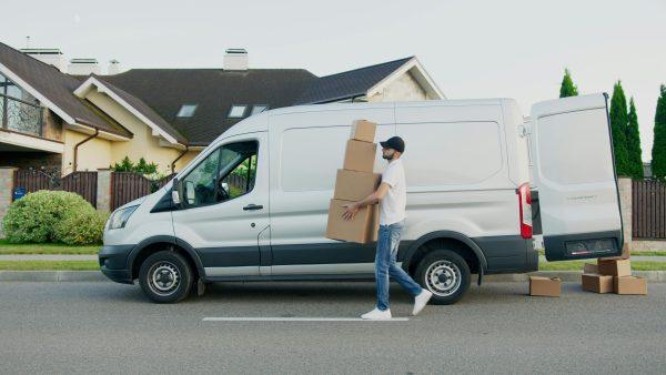 White van with person carrying pachages to be delivered