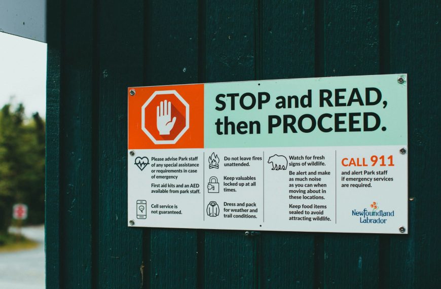 A safety sign reading 'STOP and READ, then PROCEED', serving as a visual metaphor for the necessity of pausing to establish robust AI governance and compliance frameworks before deployment.