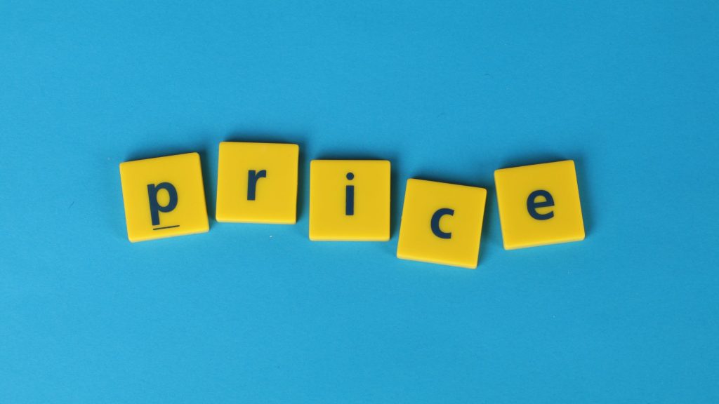 Yellow letter tiles spelling the word 'price' on a bright blue background, representing the concept of The Pricing Trap in SME commercial strategy.