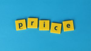 Yellow letter tiles spelling the word 'price' on a bright blue background, representing the concept of The Pricing Trap in SME commercial strategy.